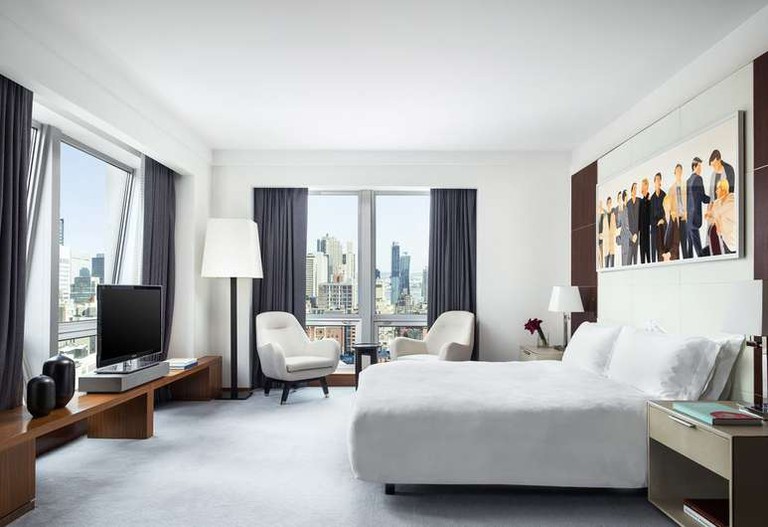 Stylish corner room in white and charcoal hues, floor-to-ceiling windows and artwork at the Langham, New York, Fifth Avenue