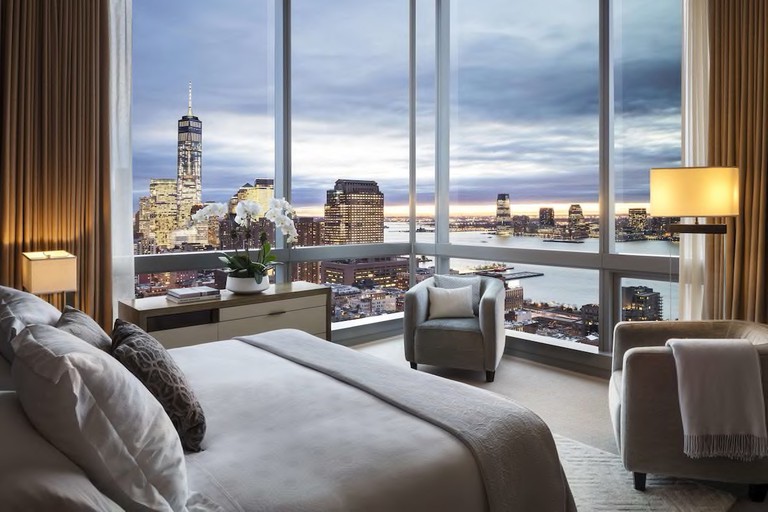 Wraparound windows offer panoramic views of lower Manhattan, the One World Trade building and across the Hudson River from this hotel room at The Dominick.